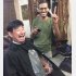 郊外の散髪店で髪を切る小田切拓氏。日本人は初めてと店主は大興奮（2019年西岸）／（写真提供）小田切拓