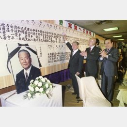 衆参両院同日選で自民圧勝、当選者の名前に花を付ける鈴木善幸総務会長。その右は桜内義雄幹事長（1980＝昭和55＝年6月23、自民党本部）日／（Ｃ）共同通信社