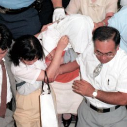 福井市内で逮捕され、移送される福田和子容疑者（中央）＝1997年7月29日（Ｃ）共同通信社