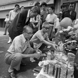 犯行現場の路上に設けられた祭壇に花やジュースなどを供える近所の人たち（Ｃ）共同通信社