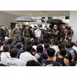 ミャンマー東部の詐欺拠点で大勢の外国人が解放された（＝手前。奥は少数民族勢力「国境警備隊（ＢＧＦ）」の幹部ら）／（ＢＧＦ関係者提供、共同）