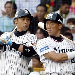 試合中に金本知憲（右）と情報を交換する筆者（Ｃ）日刊ゲンダイ