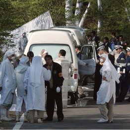 岐阜県警の捜査を受け、警察官と話す白装束の団体のメンバー（Ｃ）共同通信社