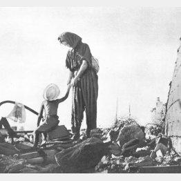 戦災のがれきの上に立つ母子　大分の空襲（1945＝昭和20＝年ごろ、大分県）　（Ｃ）大分合同新聞社／共同通信イメージズ