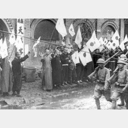 中国・天津から西に向かって日本軍が進軍するなか、旗を振って出迎える中国人住民（Ｃ）Underwood Archives／Universal Images Group／共同通信イメージズ