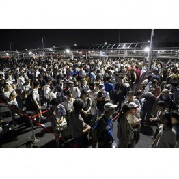 約3万人に影響したのに、14日朝方頃になってしかもたった水1000本配布とは、どうなのか（西ゲート前に並ぶ大勢の人たち＝14日午前0時近く）／（Ｃ）共同通信社