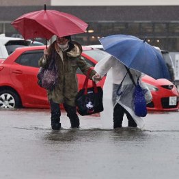 大雨で冠水した道路を歩く人たち＝2023年7月15日、秋田市（Ｃ）共同通信社
