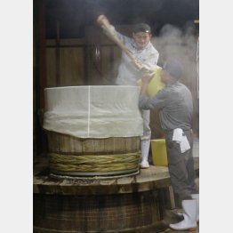 蒸し終えた米をスコップですくう作業（写真）大竹聡