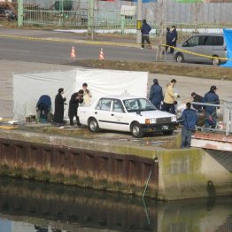 遺体の見つかったタクシーを調べる捜査員（Ｃ）共同通信社