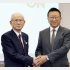 統合会見後に、握手をするヤマダHDの山田昇会長（左）とエディオンの久保允誉会長（Ｃ）共同通信社