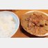 皿から汁が溢れる牛赤身の煮込みと湯気があがる白いご飯（Ｃ）日刊ゲンダイ