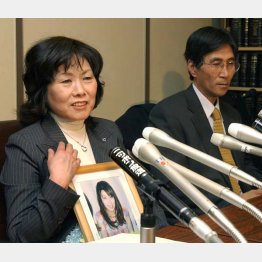 「汚名消すため闘い続ける」猪野詩織さんの遺影を胸に記者会見する母の京子さん（左）と父の憲一さん（2005年1月）／（Ｃ）共同通信社