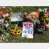 追悼の花束と「ICE出ていけ」の文字（Ｃ）ロイター